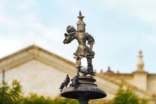 Close up of statue of Tuturutu (Elf with trumpet) with pigeons in the Plaza de Armas