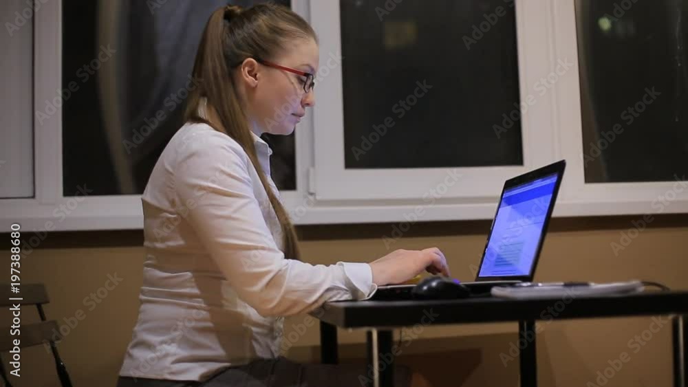 tired business woman with glasses working in the office laptop late at night. Studies late at night.Staying up late. Overworking. tired business woman with glasses working in the office laptop late at night. Studies late at night.Staying up late. Overworking.
