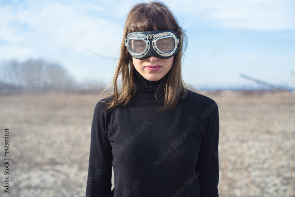 Young woman with sand goggles standing alone and posing Young woman with sand goggles standing alone and posing