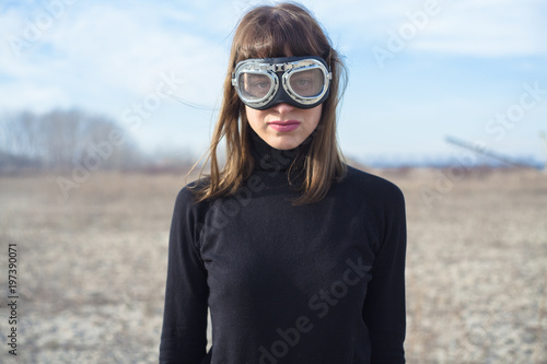 Young woman with sand goggles standing alone and posing