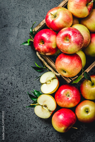 Raw apples in wooden box on concrete background. Top view, space for text.