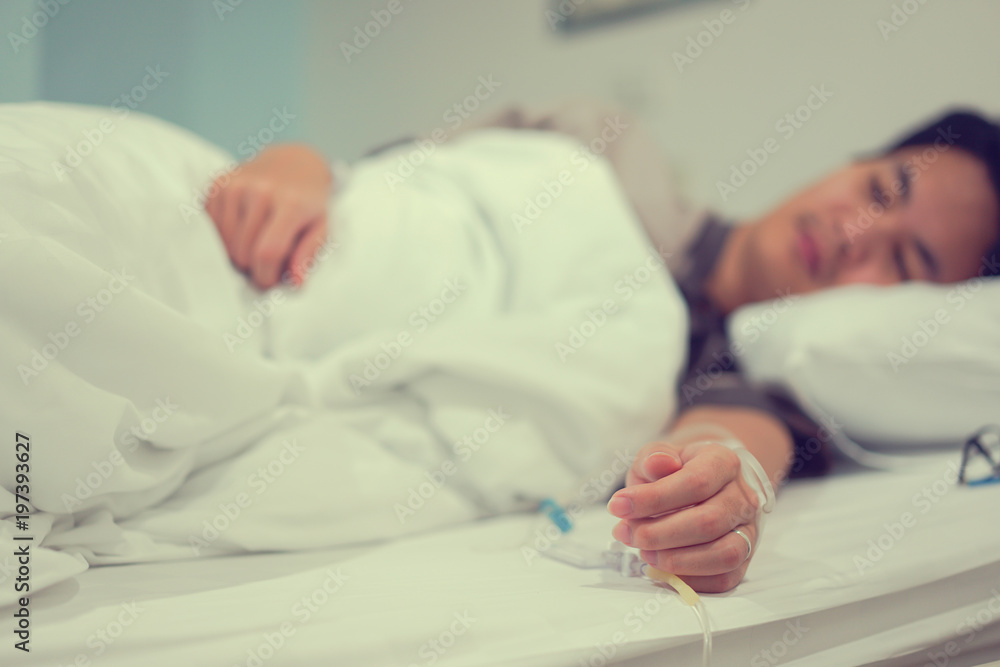 close up asian patient man's hand with label and drip , medical people concept