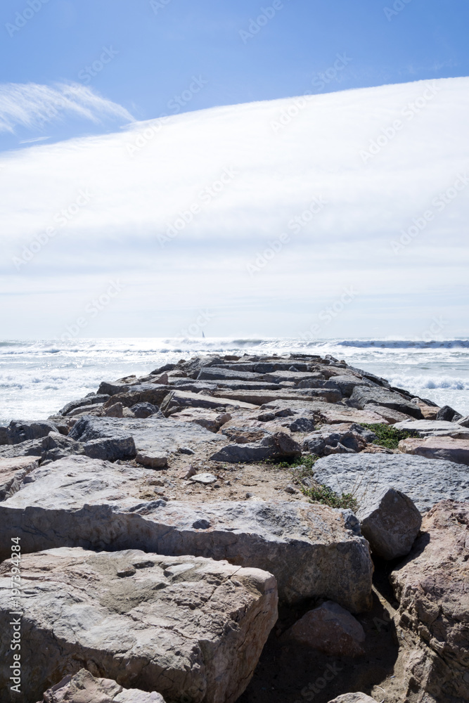 Espigón de rocas que se adentra en el mar para proteger la arena.