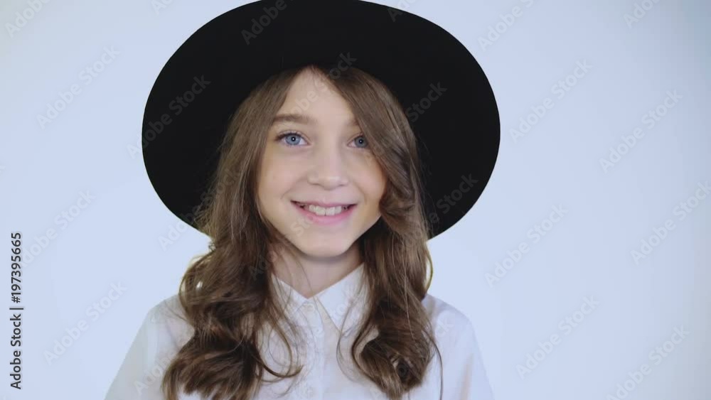 Stylish modest girl weared in hat and shirt easy smiling at camera Stylish modest girl weared in hat and shirt easy smiling at camera