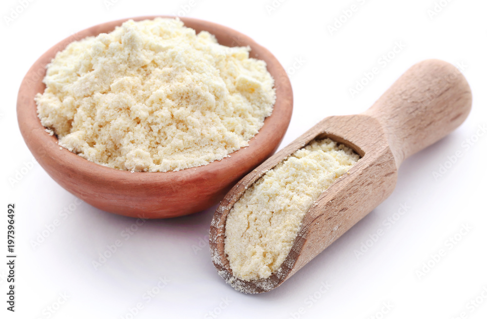 Gram flour in bowl and wooden scoop Gram flour in bowl and wooden scoop