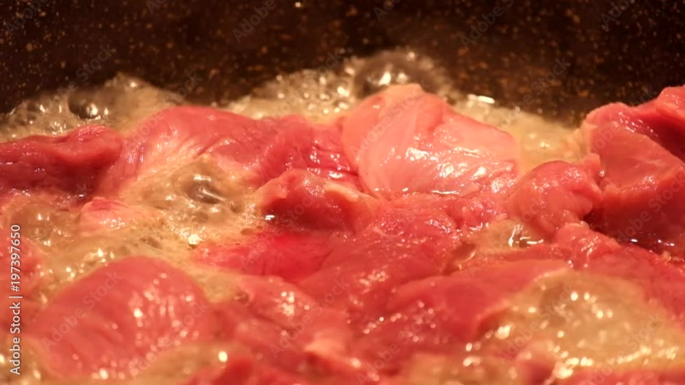 Meat with a high moisture content is fried in a frying pan and in the process emits a lot of water Meat with a high moisture content is fried in a frying pan and in the process emits a lot of water