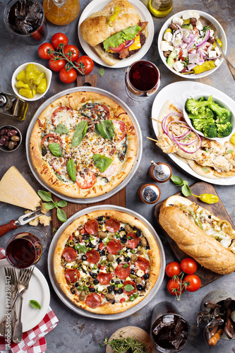 Big dinner with pizza and sandwiches