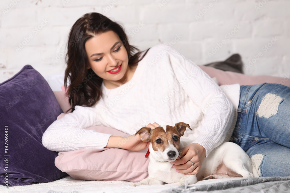 Girl lying on the bed with her puppy. Photographie retouchee Girl lying on the bed with her puppy. Photographie retouchee