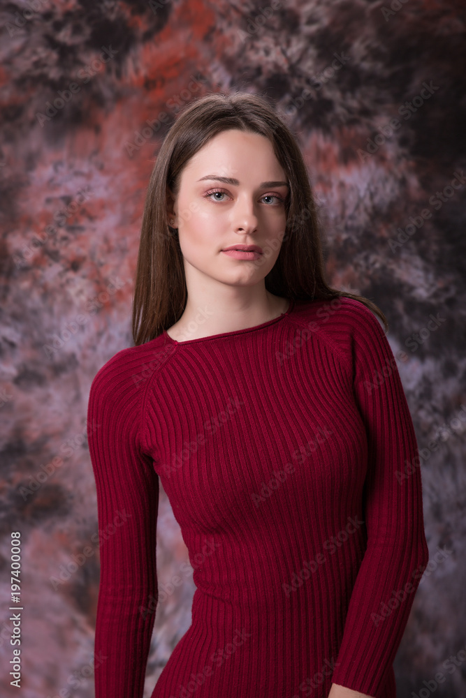 Fototapeta premium Portrait of a beautiful young woman in red dress