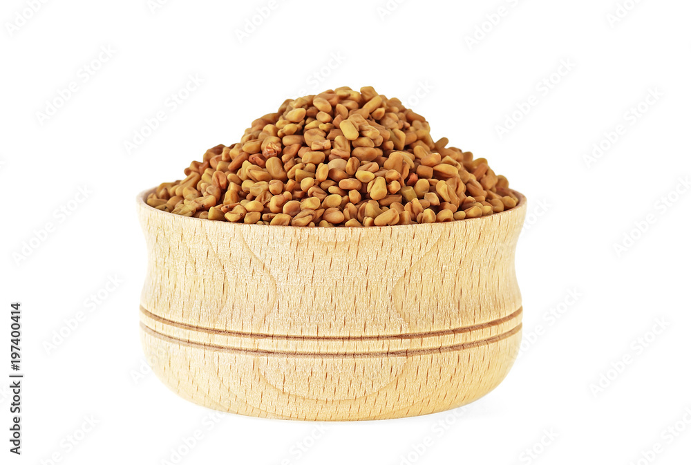 Fenugreek seeds in wooden bowl on white background Fenugreek seeds in wooden bowl on white background