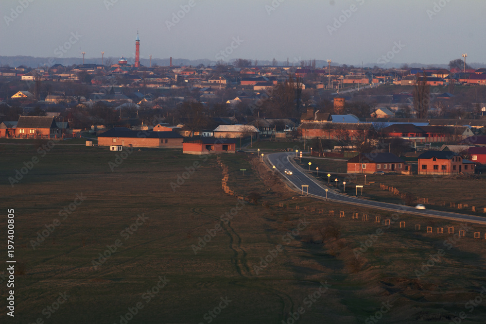 The village in the Chechen Republic, lit by rays of sunset.
