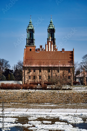 Urban landscape with river Warta and the cathedral towers in winter in Poznan