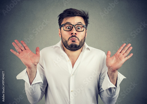 Foto Ignorant man shrugging with shoulders