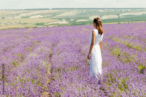 A girl is walking in a lavender field