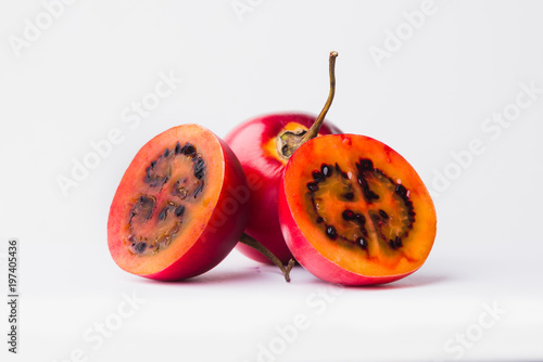 Red Tamarillo with a slice over white background photo