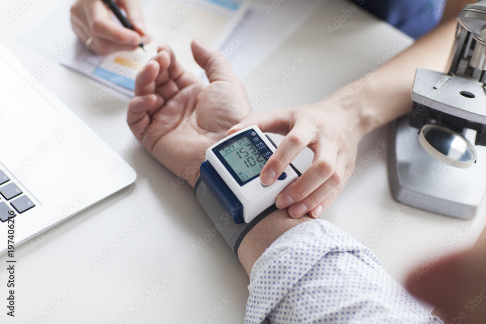 A young female doctor examining a pressure of his older patient. Hypertension A young female doctor examining a pressure of his older patient. Hypertension