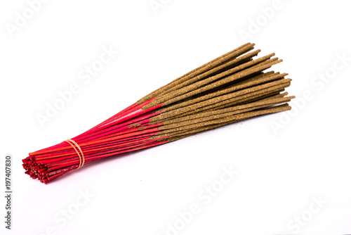 Close-up a bunch of incense sticks isolated on white. Incense use in religious ritual popular in Vietnam.Its burned to intend as a sacrificial offering to various deity or to serve as an aid in prayer photo