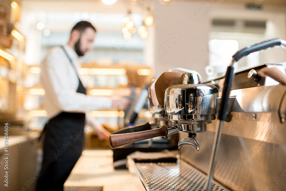 Professional coffee machine in the cafe with barista on the background
