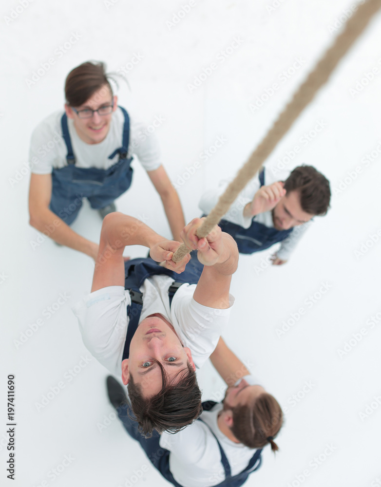 view from the top.a young man climbing up the rope. view from the top.a young man climbing up the rope.