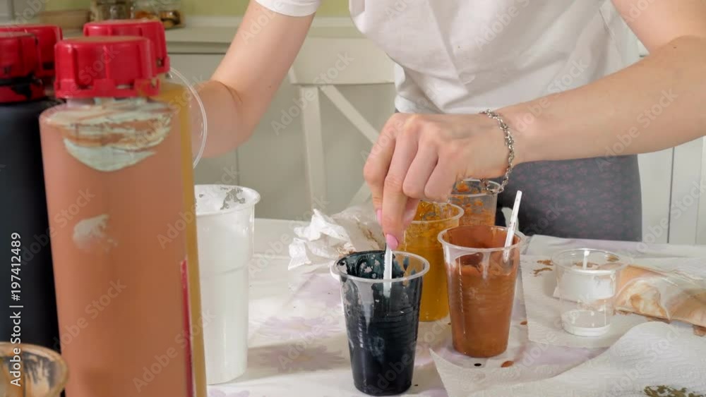 woman prepares and paints paints for drawing a picture of fluid art woman prepares and paints paints for drawing a picture of fluid art