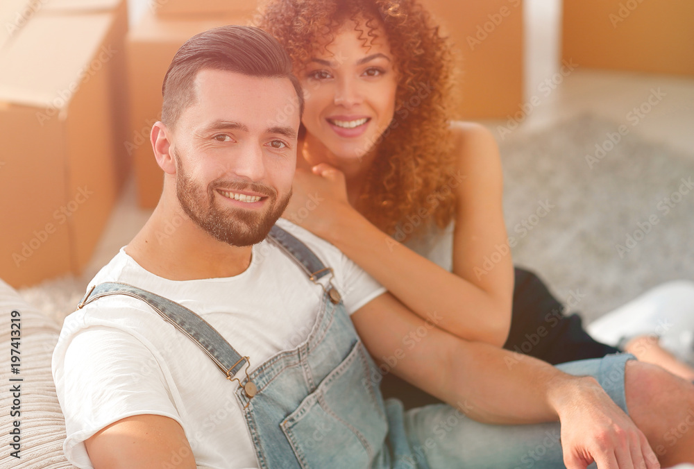 Young couple sitting on the floor in a new apartment Young couple sitting on the floor in a new apartment