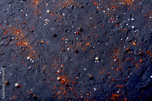 Red spices  salt and pepper on black marble. Black abstract background. Top view.