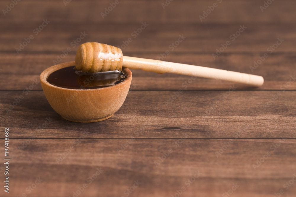 Honey with a Honey Spoon in a Small Wooden Bowl Honey with a Honey Spoon in a Small Wooden Bowl