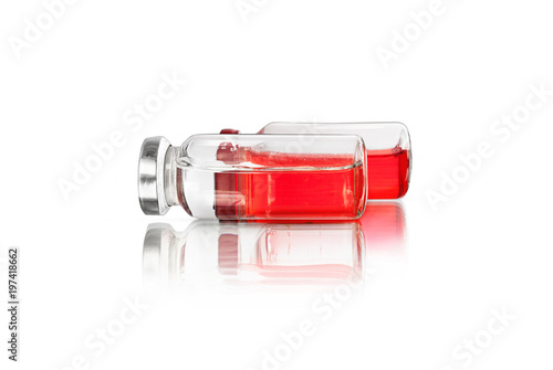 Glass jars with a red and transparent liquid, isolated on a white background photo