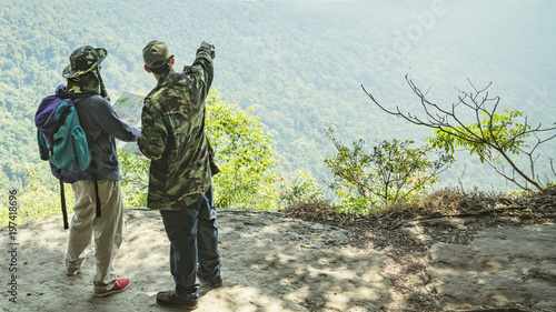 Three man on the edge of mountain feel happy.