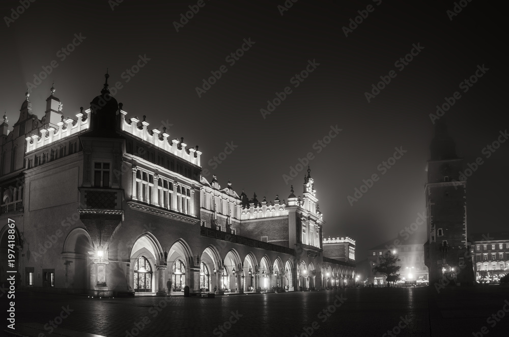 Market hall and town vity hall at main Cracow square at misty night - black and white haloween version Market hall and town vity hall at main Cracow square at misty night - black and white haloween version