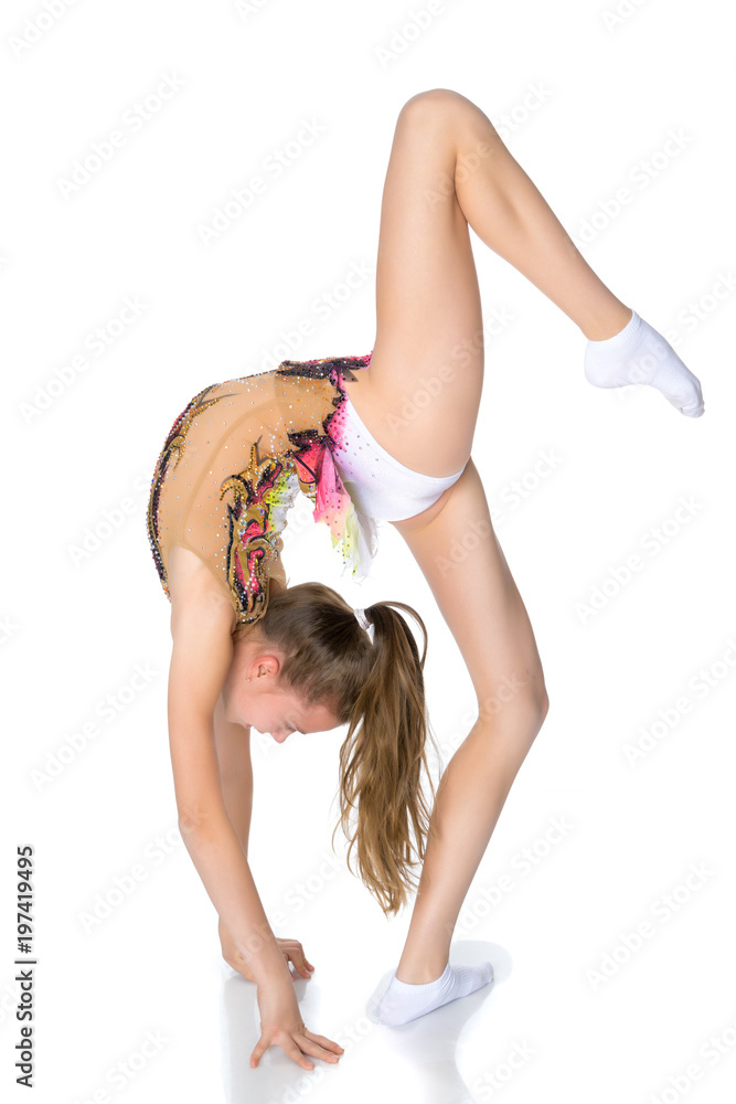 Fototapeta premium The gymnast performs a bridge with a raised leg.