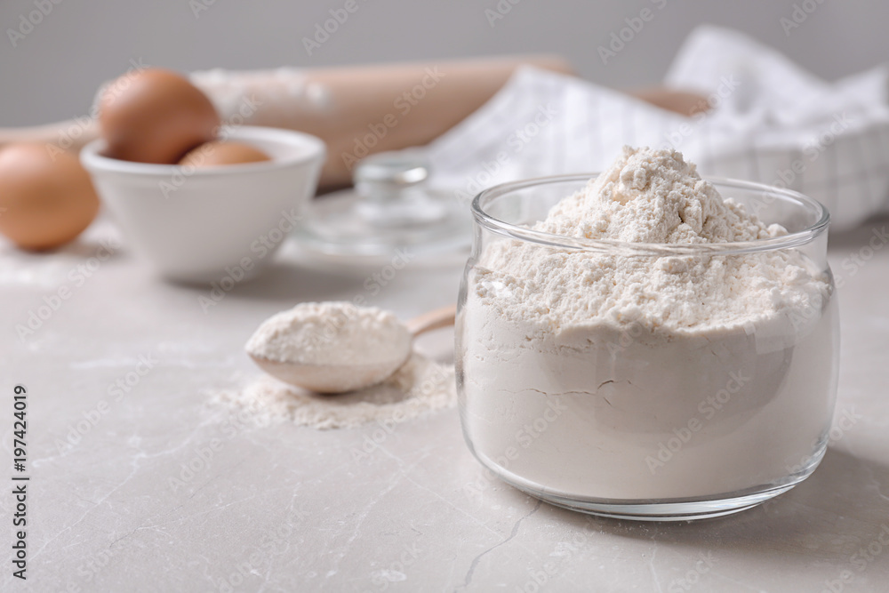 Glass bowl with flour on table Glass bowl with flour on table