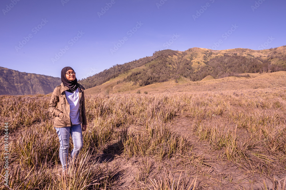 A teenager pose with Bromo mountain as background at East Java Indonesia