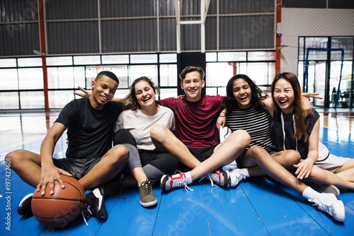 Fototapeta Naklejka Na Ścianę i Meble -  Group of young teenager friends on a basketball court relaxing portrait