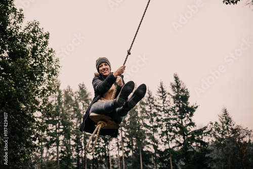 Girl swinging from forest rope swing