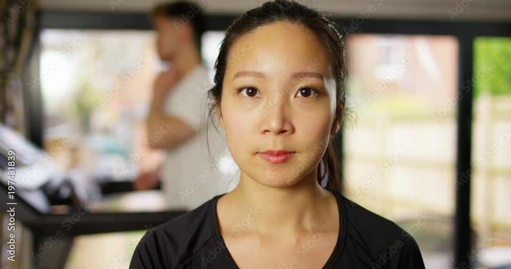 4K Serious girl working out with weights at the gym & man running on treadmill in background 4K Serious girl working out with weights at the gym & man running on treadmill in background