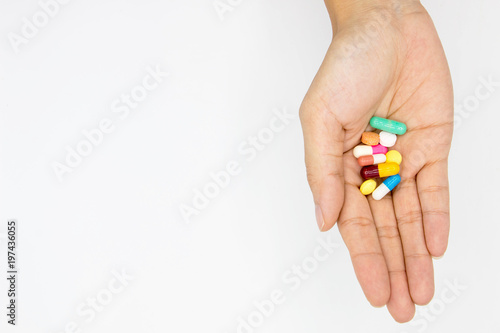 multiple colors pills in  hand  on white background.