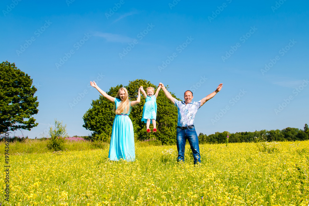 Young happy caucasian family with baby girl celebration fathers day outdoors. hafving fun. Summer, green field, blue sky Young happy caucasian family with baby girl celebration fathers day outdoors. hafving fun. Summer, green field, blue sky