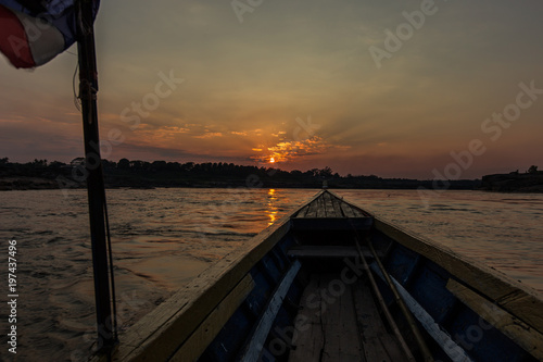 Front view of Old fishing boat with Thailang flag and golden sunset as a background.