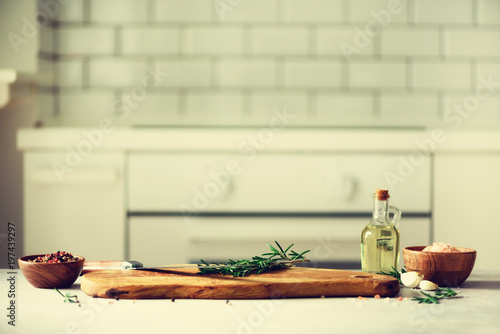 Food cooking ingredients on white kitchen design interior background with rustic wooden chopping board in center  copy space