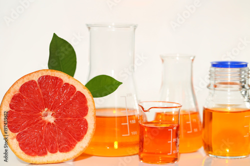 Vitamin C concept.Solution of vitamin C in laboratory flasks and citrus fruits grapefruit in a cut on a light background.Health and Beauty