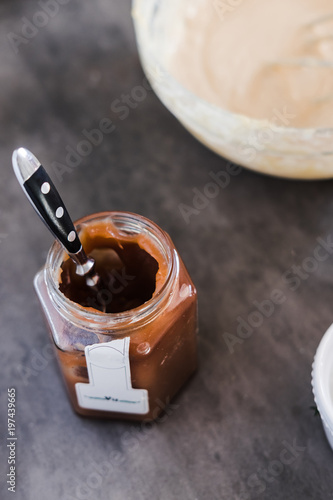 Chestnut, caramel puree jar and a bowl with cream cheese filling. Dark food photography concept. Vertical, overhead