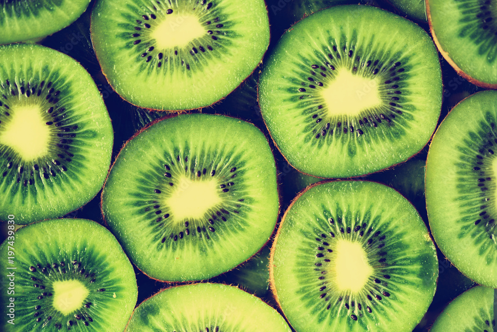 Fresh organic kiwi fruit sliced. Food frame with copy space for your text. Banner. Green kiwi circles background Fresh organic kiwi fruit sliced. Food frame with copy space for your text. Banner. Green kiwi circles background