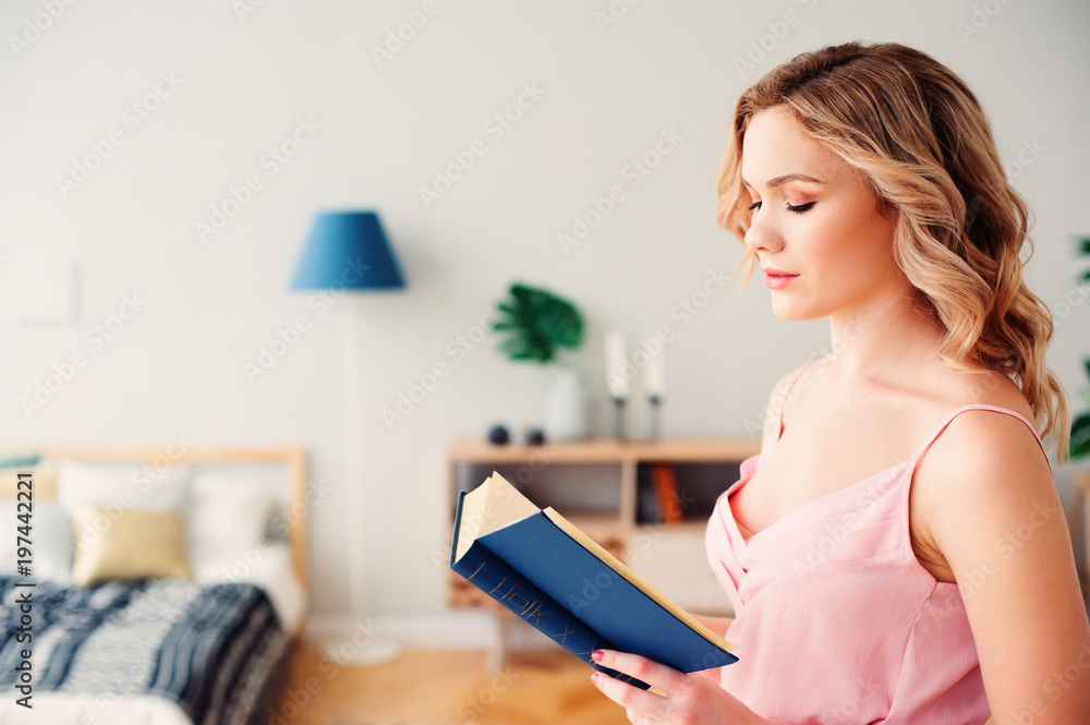 young beautiful woman reading book at home in cozy weekend morning, wearing trendy spring skirt and top. young beautiful woman reading book at home in cozy weekend morning, wearing trendy spring skirt and top.