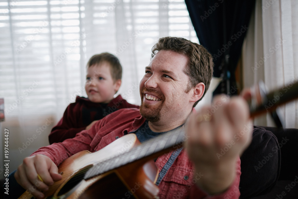 Obraz premium father teaching son how to play guitar