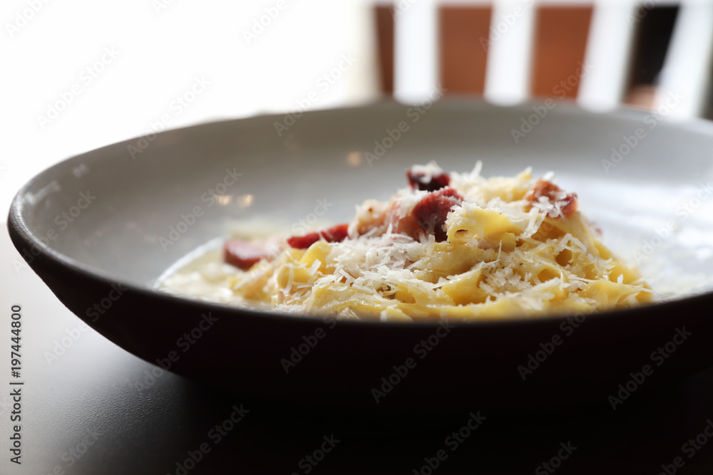 spaghetti carbonara white sauce with bacon on wood background in restaurant spaghetti carbonara white sauce with bacon on wood background in restaurant