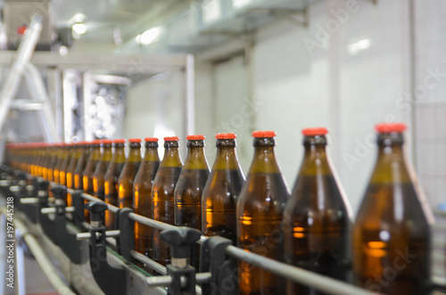 Row of glass bottles on the conveyor belt. Selective focus.