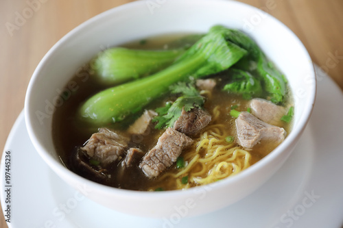 Chinese noodles with pork on wood background