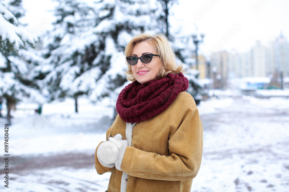 Portrait of happy mature woman in snowy park on winter vacation Portrait of happy mature woman in snowy park on winter vacation