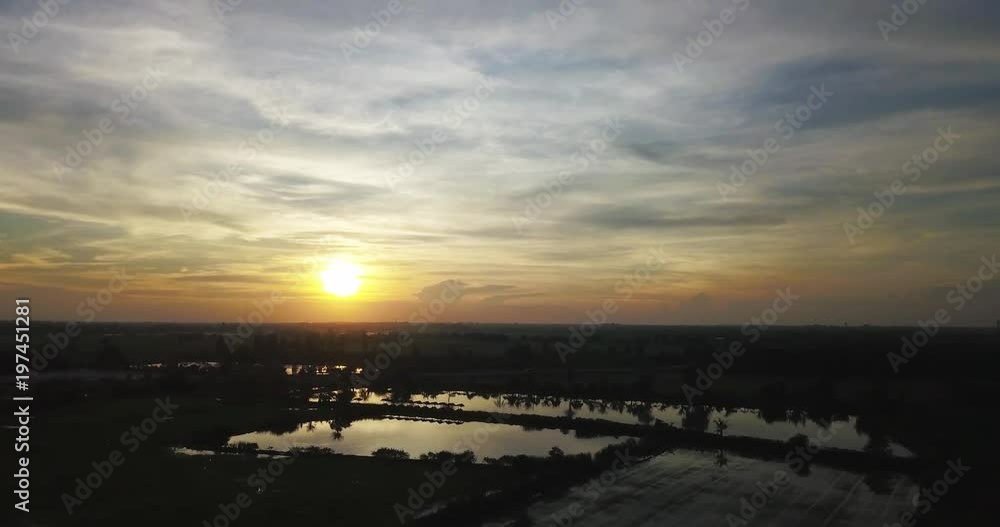 Aerial View, Flying over the rice field and highway with beautiful sky and clouds on sunset Landscape nature with aerial camera shot, Thailand.